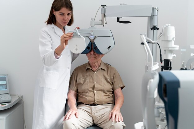 An eye doctor conducting a vision test for an elderly male patient with a phoropter.